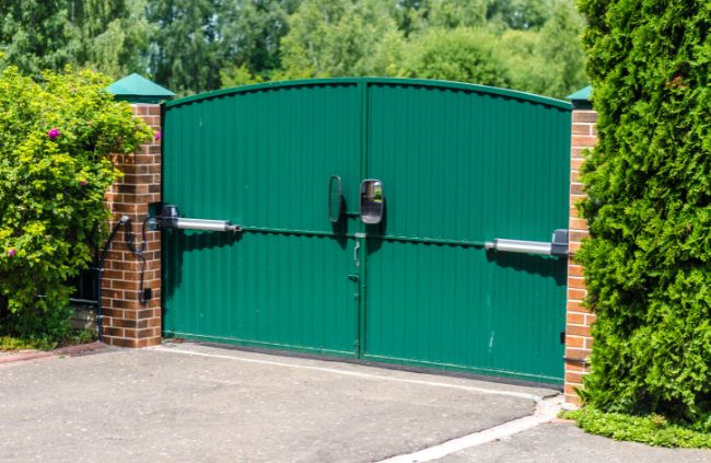 Motorised swing gate system installed by Auto Gate Guys Perth, featuring green double gates and brick pillars for a secure driveway entrance Motorised swing gate system installed by Auto Gate Guys Perth, featuring green double gates and brick pillars for a secure driveway entrance